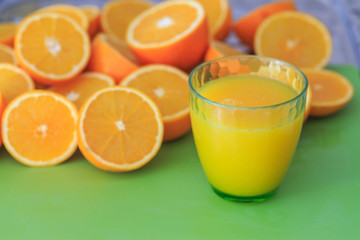 Freshly squeszed orange juice with half oranges.