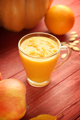 Glass of fresh pumpkin smoothie on wooden background