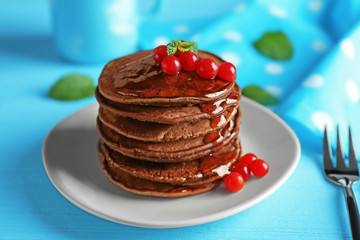 Delicious chocolate pancakes with  viburnum on blue wooden table