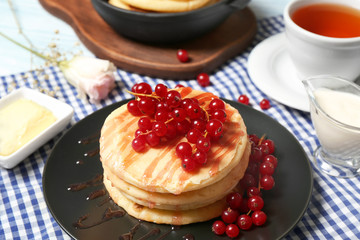 Stack of fresh pancakes with berries on table