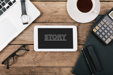 Story text on tablet computer, Office desk with computer technol