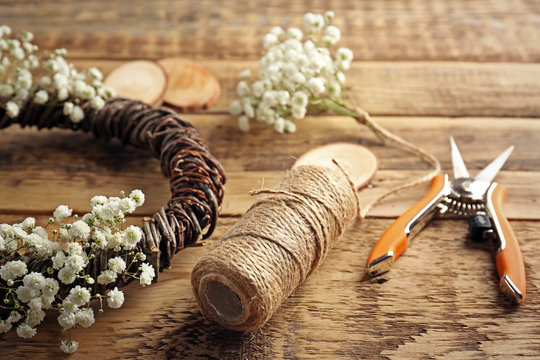 Beautiful floral wreath with tools for hand-made on wooden background