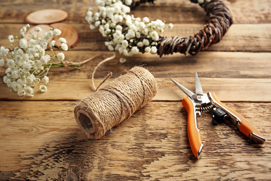 Beautiful floral wreath with tools for hand-made on wooden background