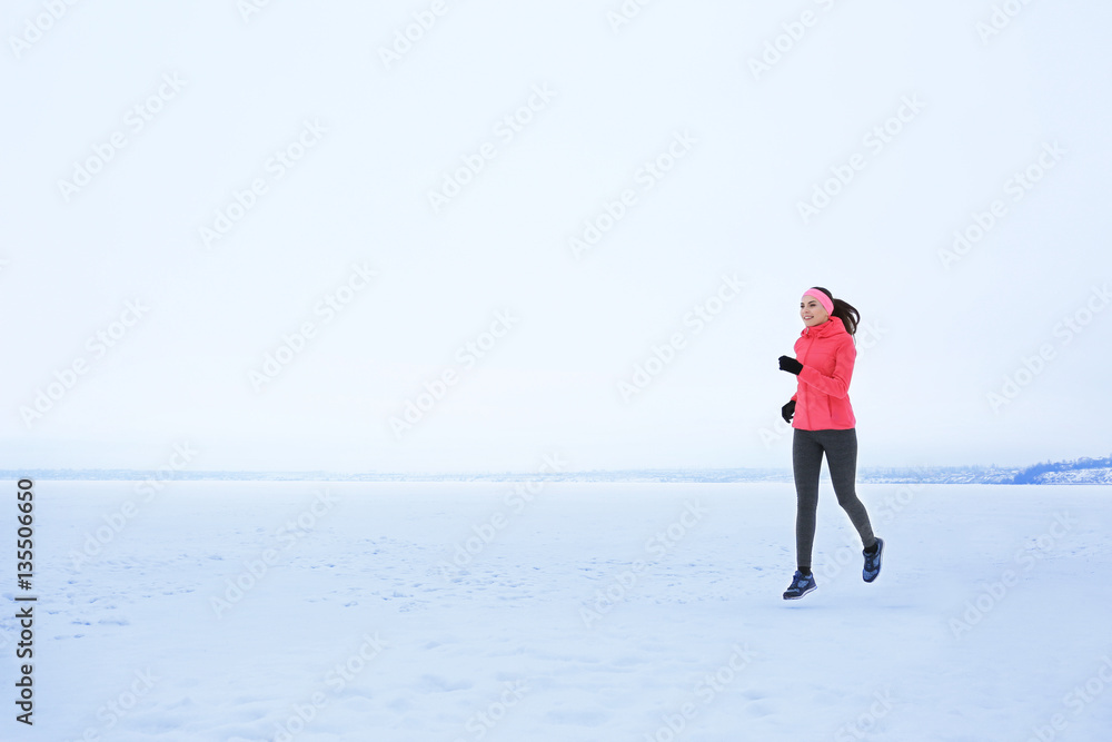 Sticker Young beautiful woman jogging on winter day