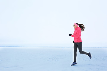 Young beautiful woman jogging on winter day