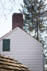 Fototapeta na wymiar Old Wood Sided House with Brick Chimney