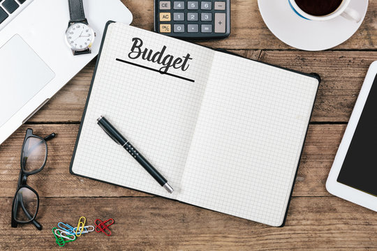Budget text on note pad, Office desk with computer technology, h