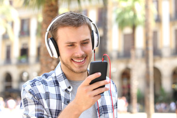 Guy listening music on line in the street