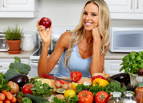 Young woman with appla in the kitchen.