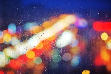 rain drops on glass window viewing city lights on a dark weather evening. raining scenery...