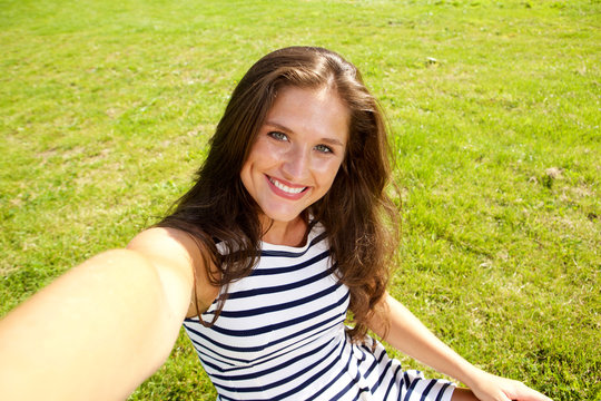 happy pretty woman taking selfie photo on grass