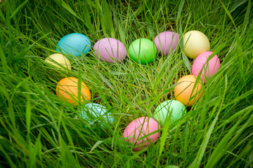 background with colorful easter eggs on meadow in heart shape
