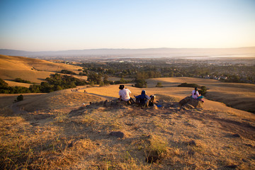 Obraz premium Family sits on top of a hill in Fremont, California to watch the sunset and fireworks