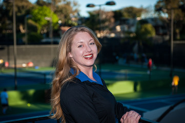 Fair skinned red head woman smiling while wearing black athletic jacket.