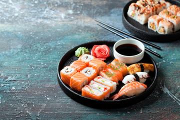 Sushi set nigiri and rolls served in round plate, selective focus