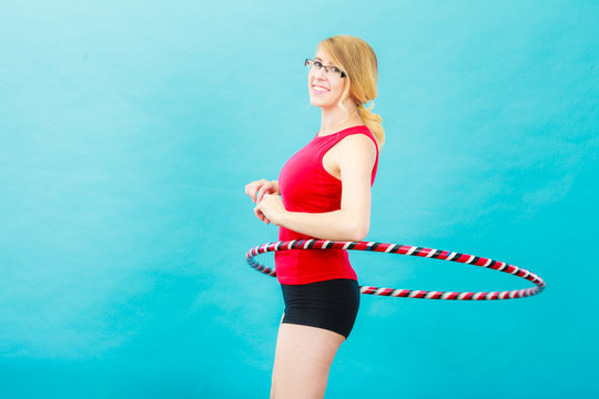 Fit woman with hula hoop doing exercise