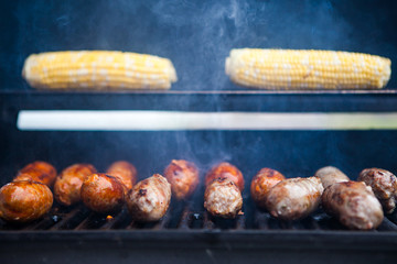 Corn and sausage on a summer gas grill barbecue being cooked