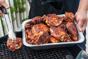 Seasoned grilled chicken cooking on barbecue in summer