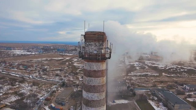 Top of the pipe with steam during the winter heating season (aerial shot). 4K. Pipes of a thermal power plant.