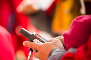 Caucasian hand holds a handheld gps device