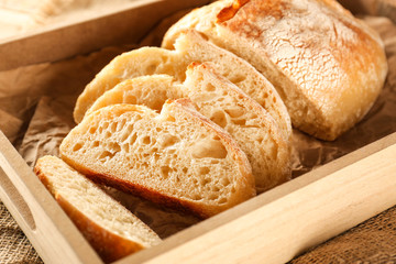 Sliced fresh bread in wooden box closeup