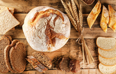 Different types of fresh bread on wooden background