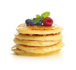 Delicious pancakes with berries and sweet syrup on white background