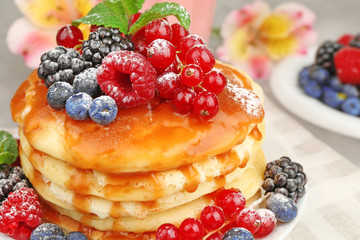 Delicious pancakes with berries and sweet syrup, closeup