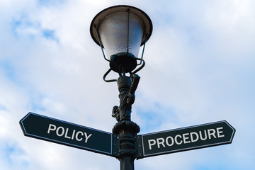 Policy versus Procedure directional signs on guidepost