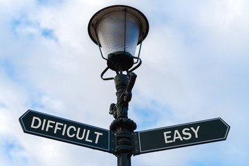 Difficult versus Easy directional signs on guidepost