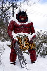 Red giant myth sculpture at Noboribetsu onsen snow winter