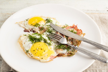 fried eggs with bacon on a plate close-up