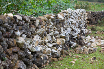 Stone wall on a hill with grass field
