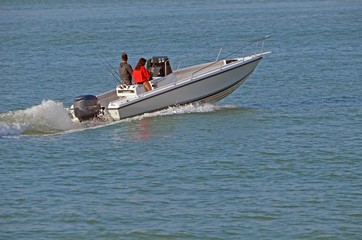 Fototapeta premium Young couple enjoying a Saturday afternoon cruise on the florida intra-coastal near Miami Beach in an open fishing boat powered by a single outboard engine.