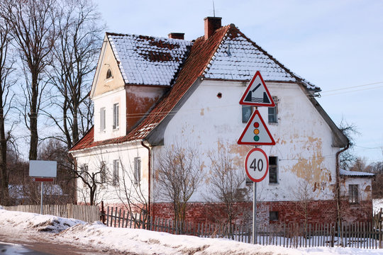 Old german building near road signs in Polessk (Labiau). Kaliningrad region, Russia.