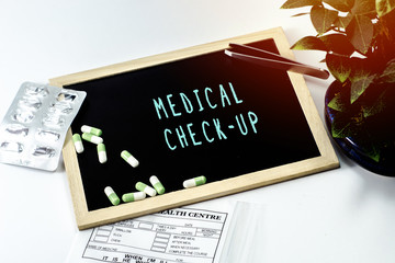 Medicine over the board written MEDICAL CHEK UP on white isolated background