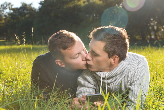 Young gays couple kissing each other lying  on the grass