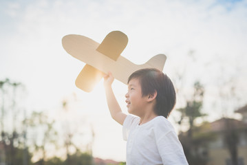 Cute Asian child playing cardboard airplane
