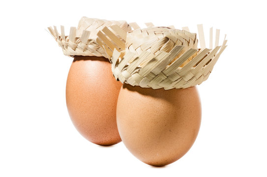 Brown eggs with straw hat isolated on white background