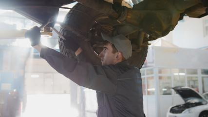 Garage automobile service - a mechanic checks the wheel, close up