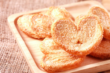 Paddle a butterfly, heart shaped patty crispy with sugar in a wooden dish for lovers on Valentine's Day