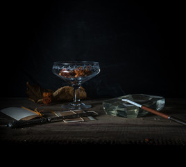 still life with ice-cream bowls and smoking a cigarette. dark background. vintage