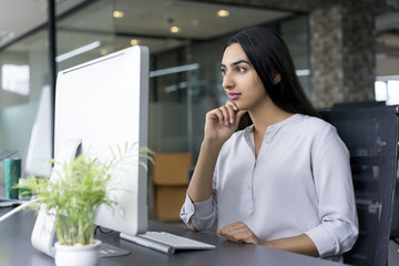 Confident young businesswoman working in office
