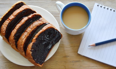 bread slice dressing creamy chocolate sauce and coffee with book