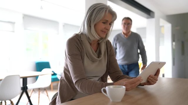 Senior couple at home using digital tablet