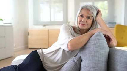Portrait of senior woman relaxing in sofa - Powered by Adobe