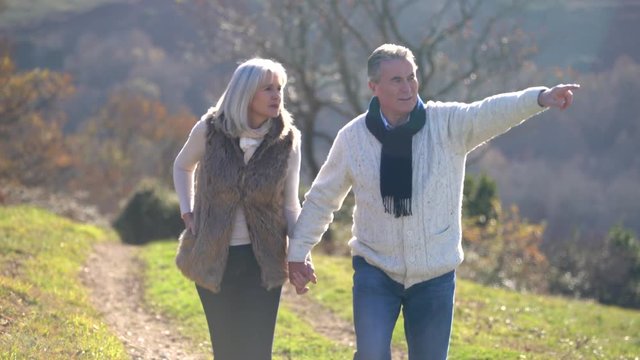 Senior couple walking in countryside on winter day