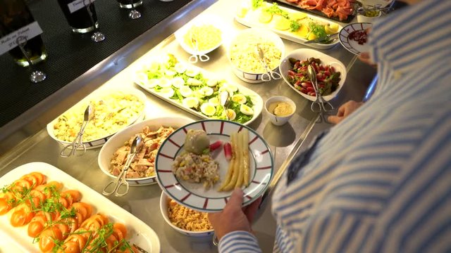 People serving themselves in restaurant buffet