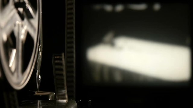 Moving of a black and white film strip with a screen in the background.