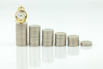 stacks of coins and  pocket watch on white a background